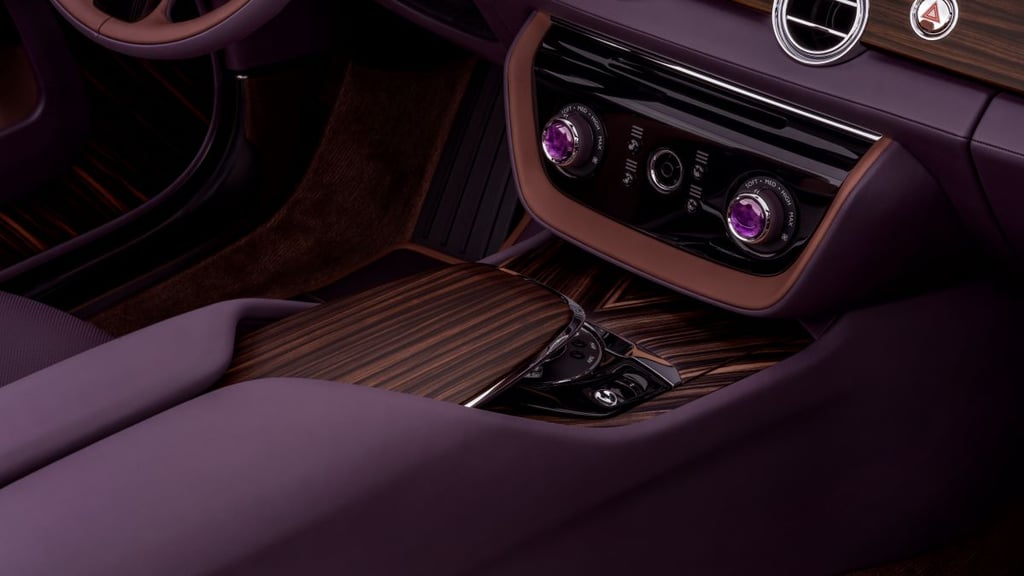 Luxurious car console with dark wood trim and purple gemstone-accented knobs.