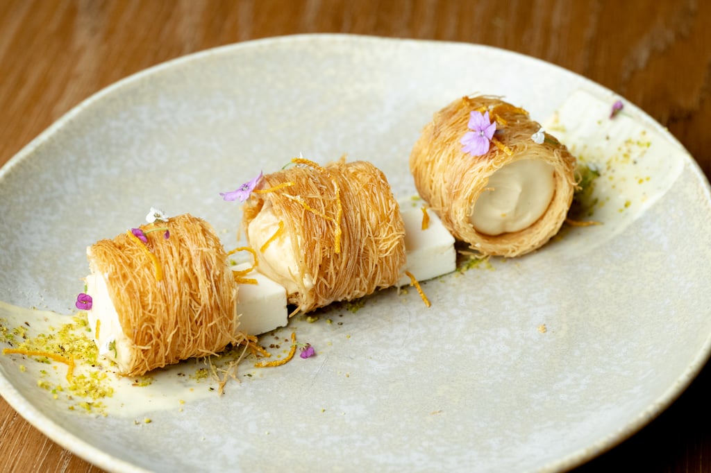 Pastries with creamy filling and garnish on a wooden table.