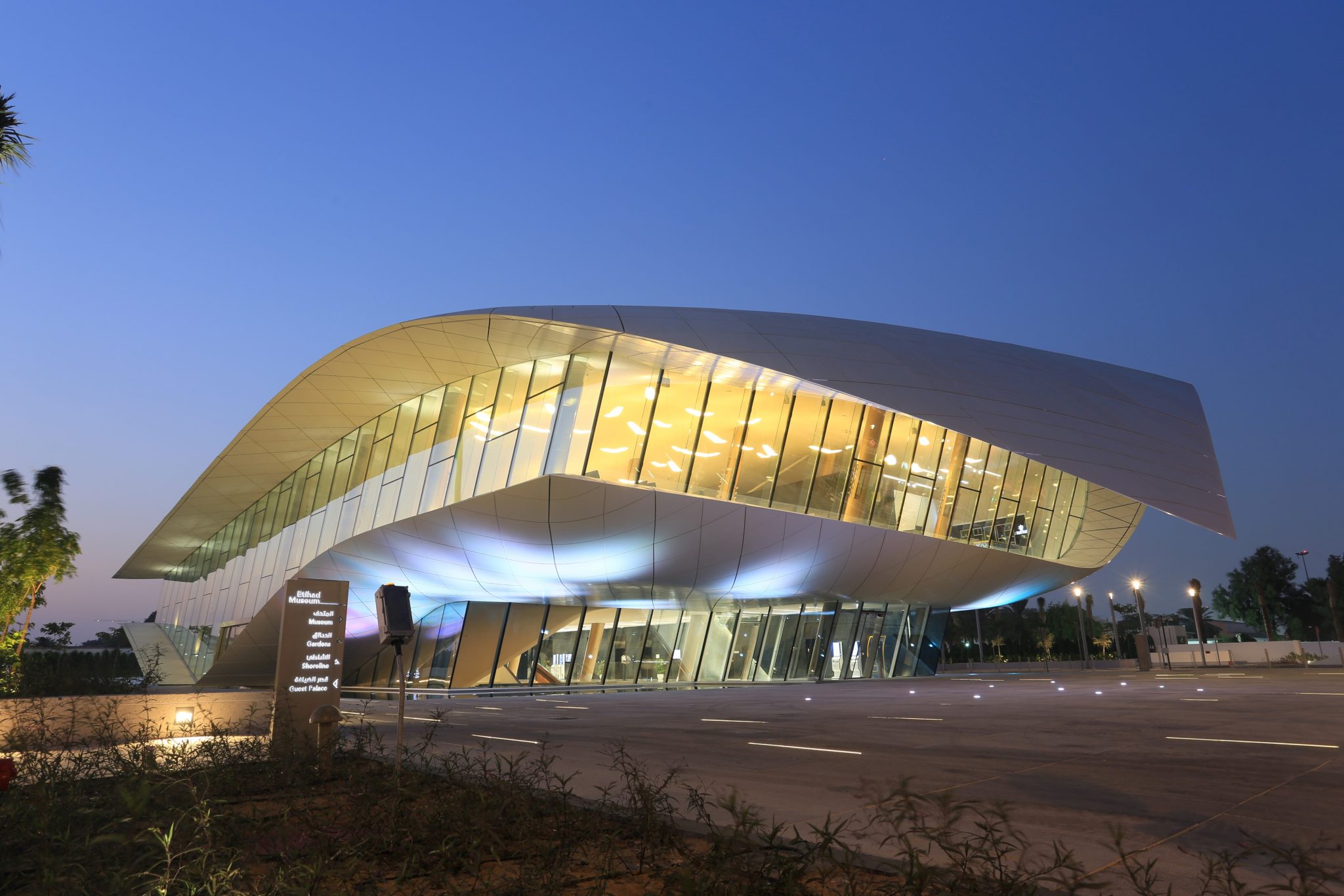 Modern glass building illuminated at dusk.