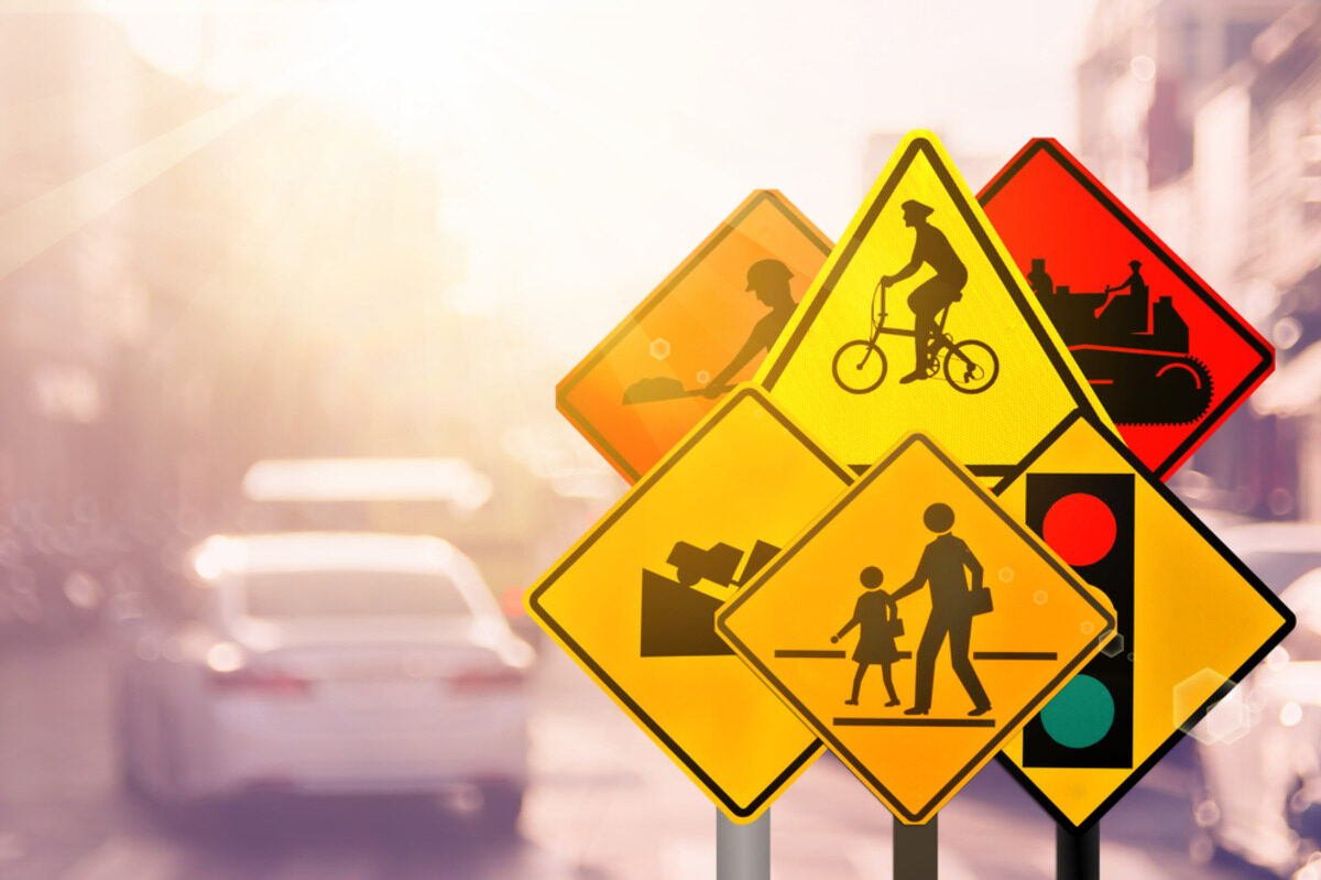 Yellow traffic signs for cyclists, pedestrians, and roadworks.