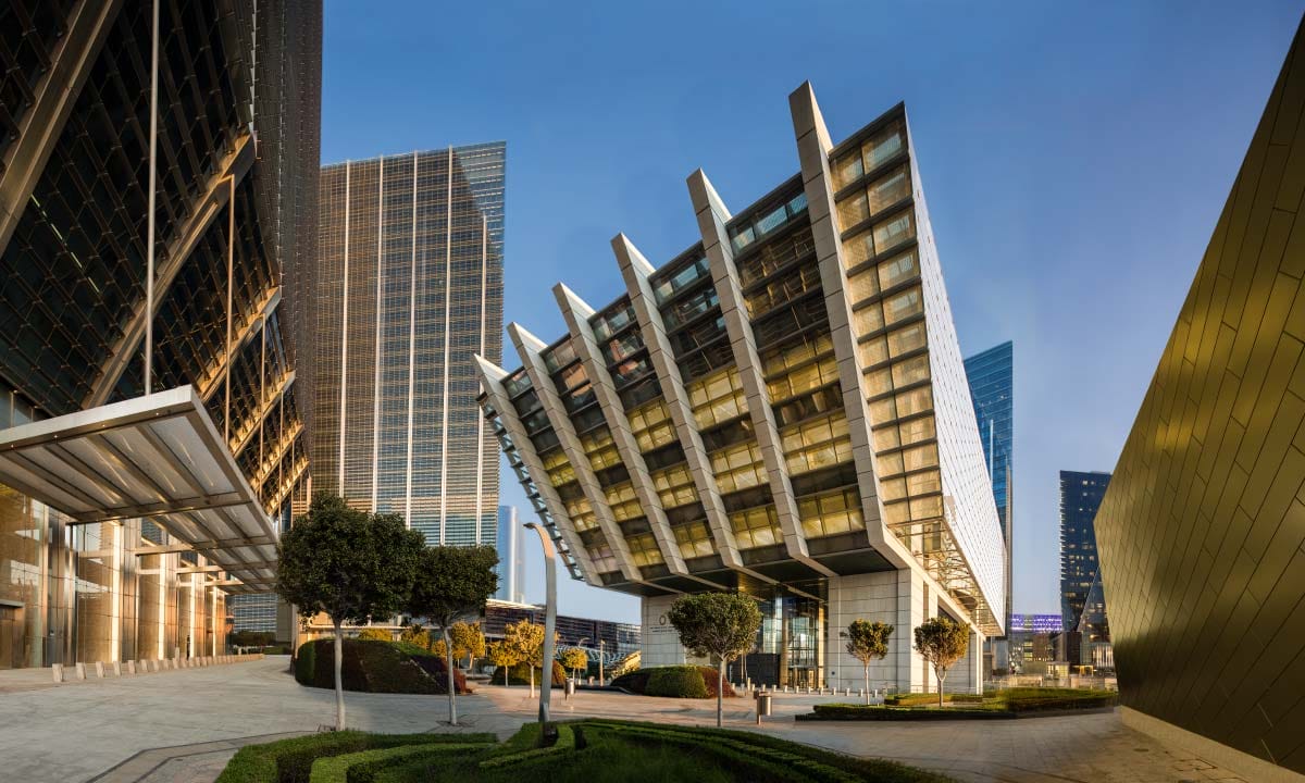 Striking modern building among skyscrapers and gardens.