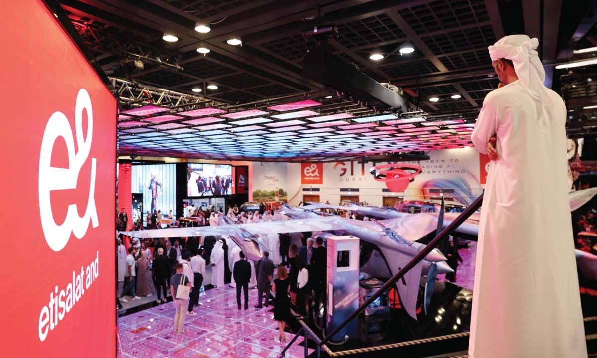 Man observes flying vehicle exhibit at convention center.