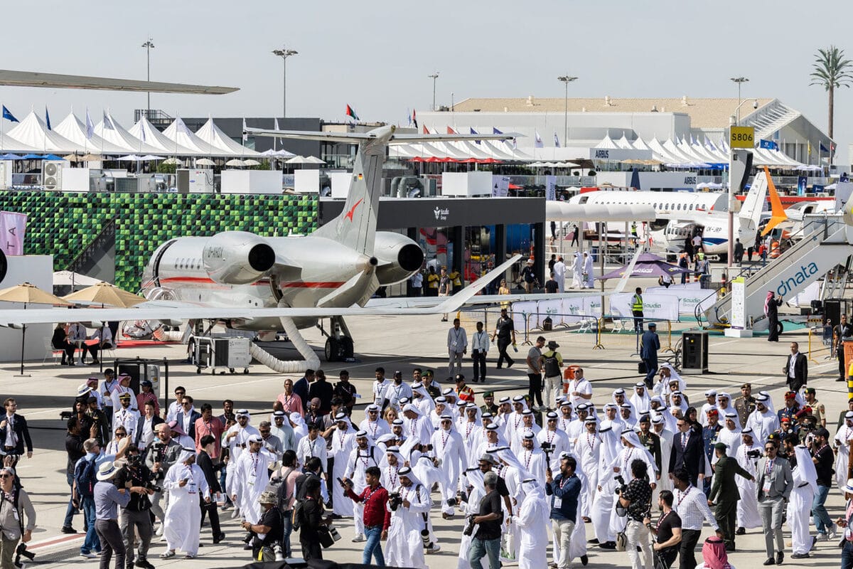 Private jet at an aviation exhibition with people taking photos.