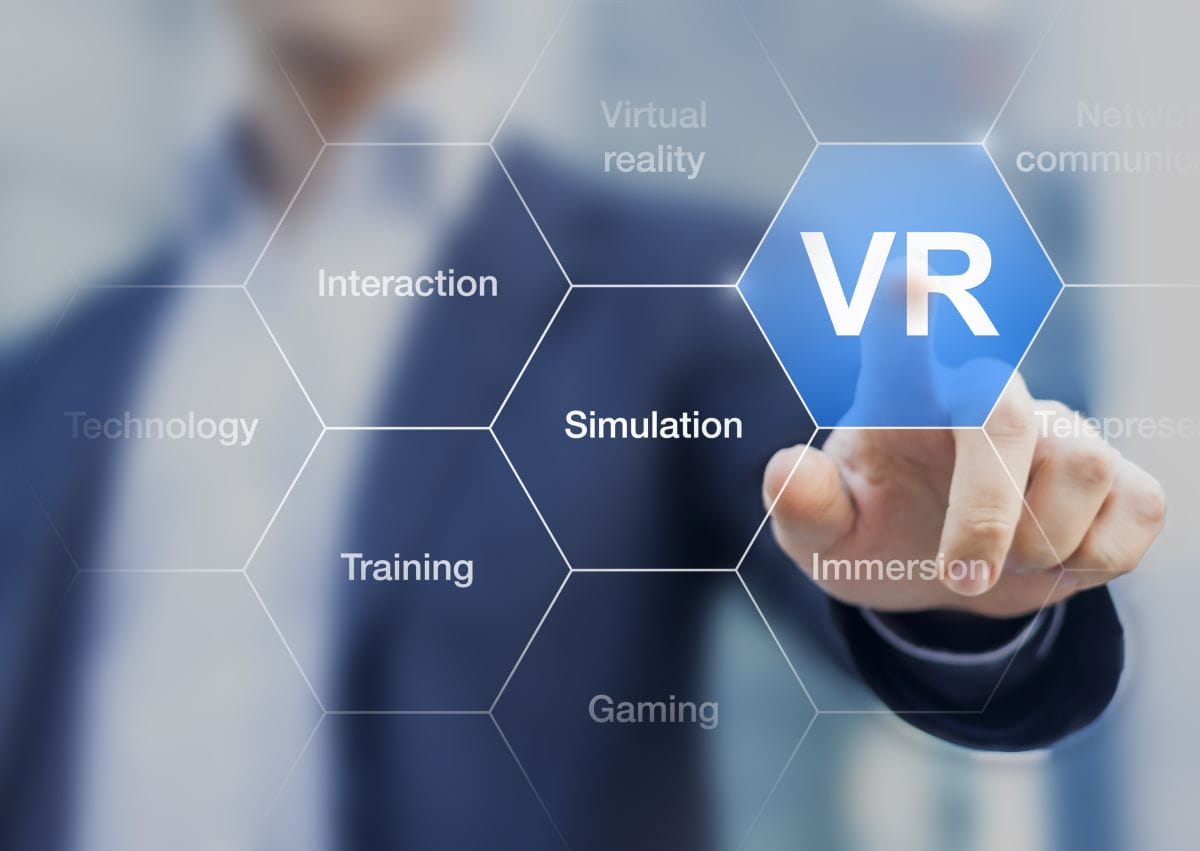 Hand using VR interface with virtual tech terms.