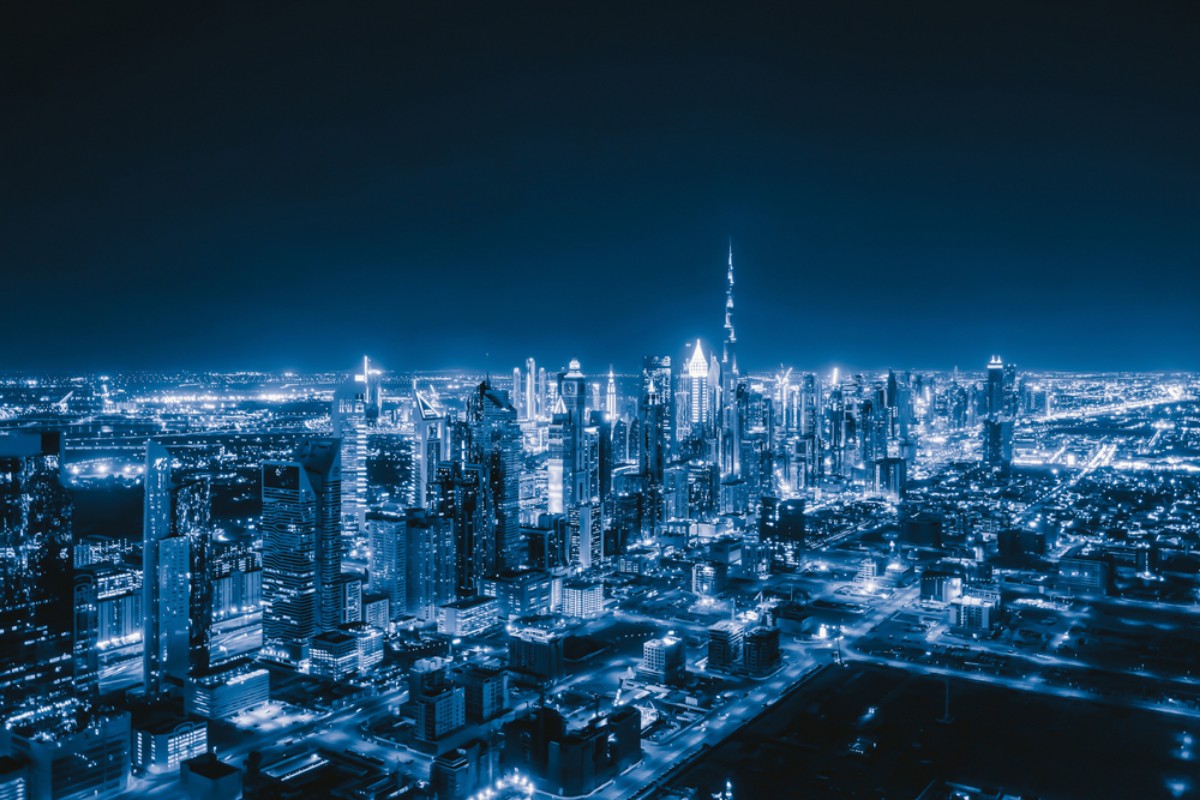 Illuminated skyscrapers in a bustling nighttime metropolis.