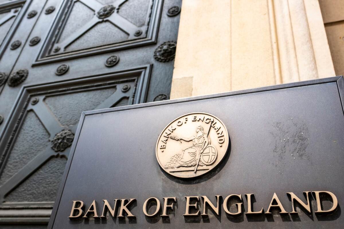 Bank of England sign with bronze emblem on a metal door.