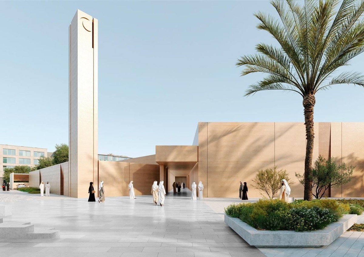 Tan mosque with minaret in sunny plaza with people.