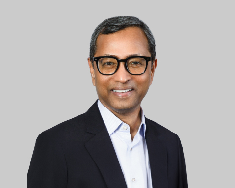 Man in glasses smiling.