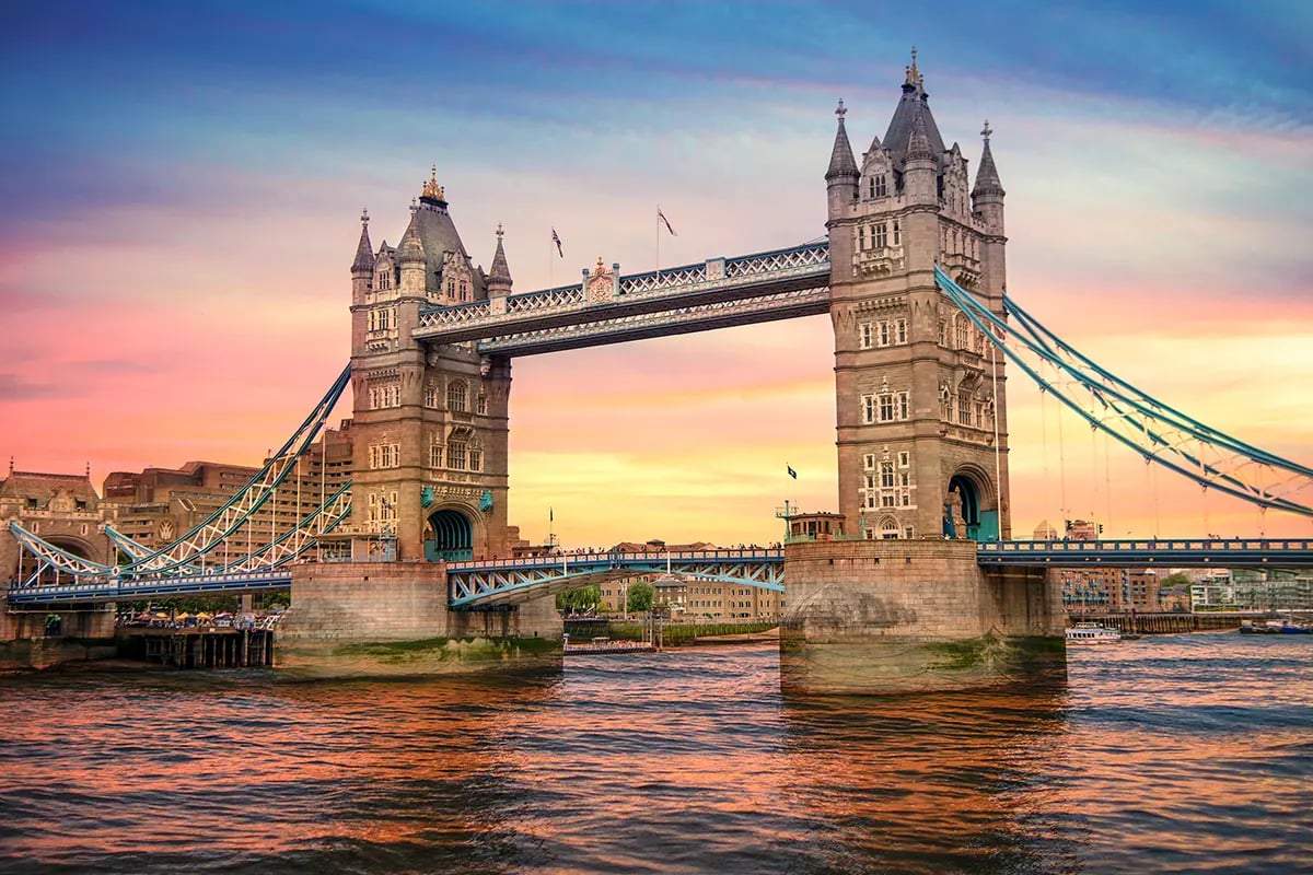 Tower Bridge at sunset with colorful sky reflected in the river.