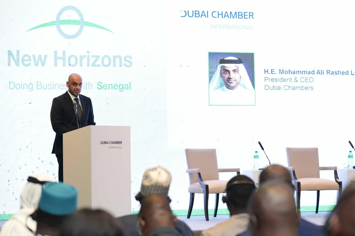 Man giving a speech with "New Horizons: Doing Business with Senegal" on screen.