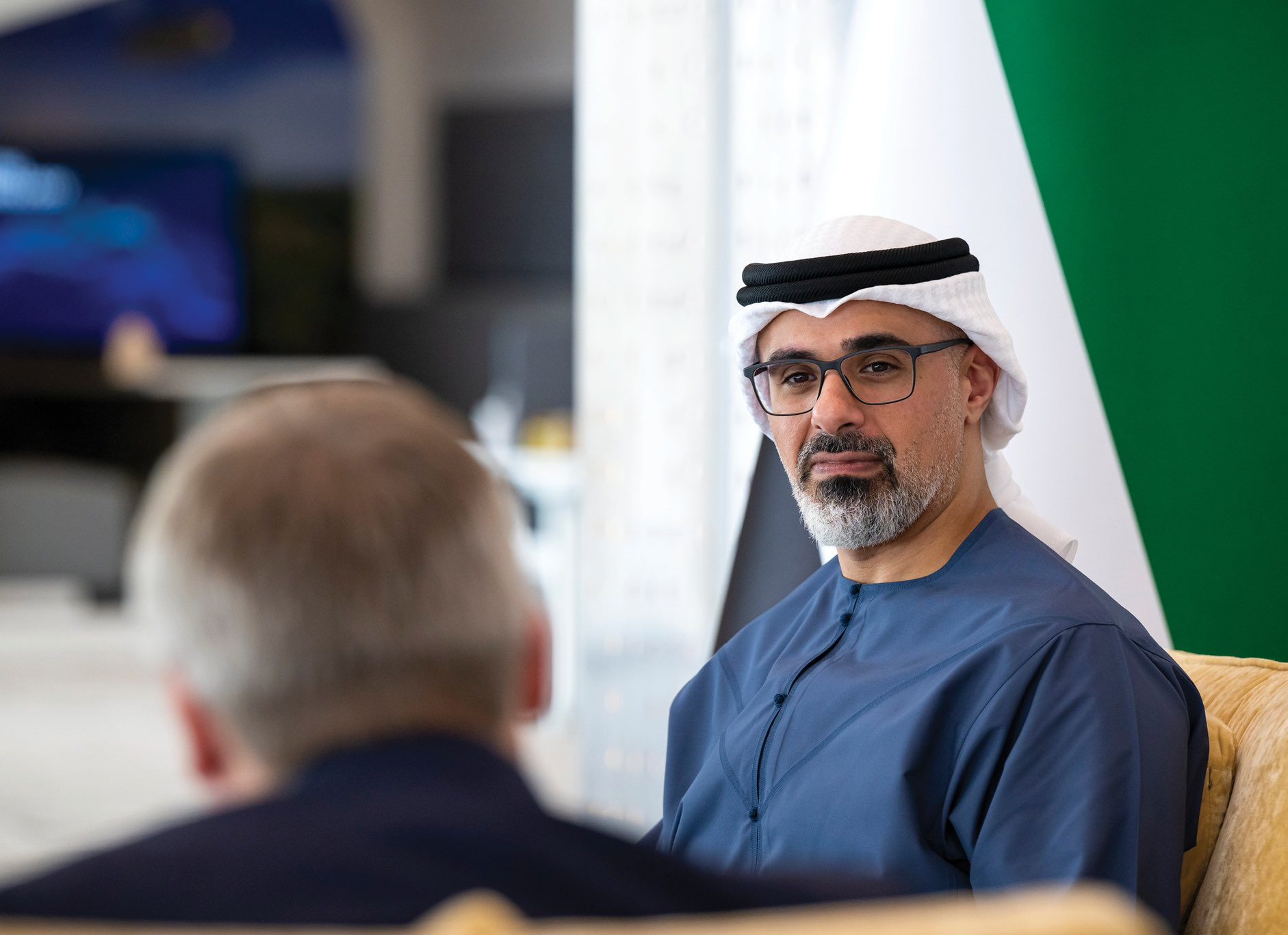Emirati man in traditional attire sitting in an office.