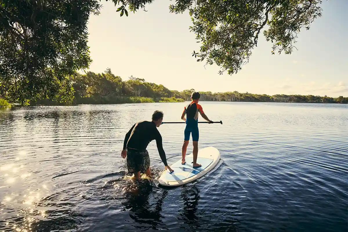 A father with his son on a surfboard