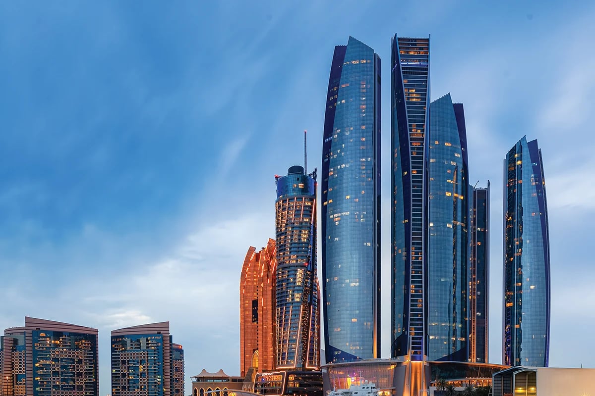 Illuminated skyscrapers at dusk.