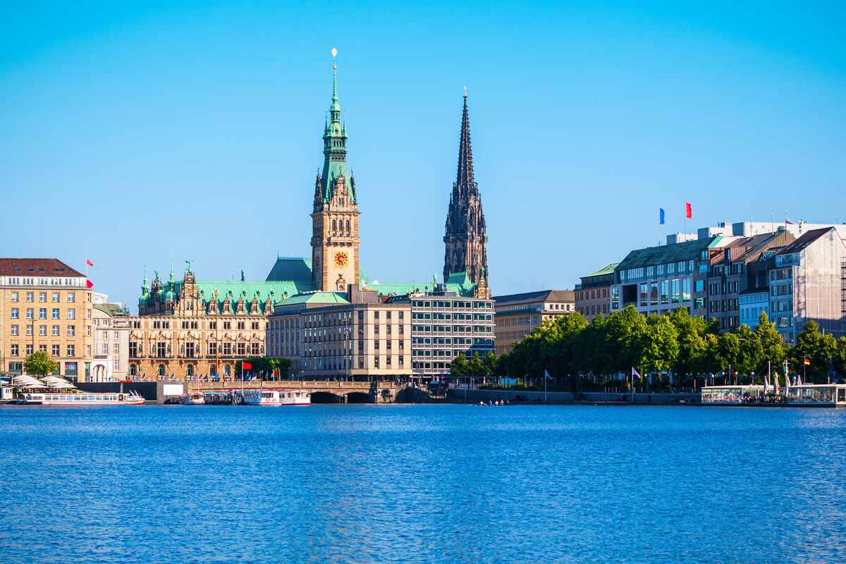 Waterfront building with spire and boats.