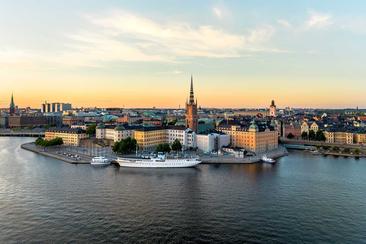 Docked ship with cityscape at sunset.
