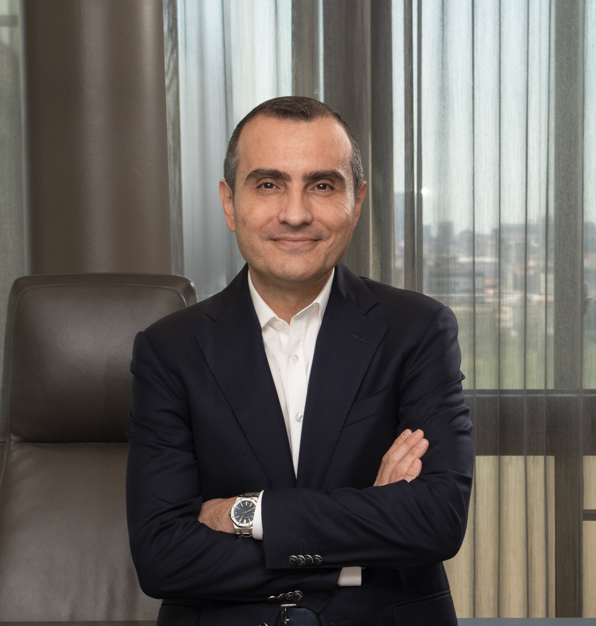 Man in a suit with wristwatch in an office.