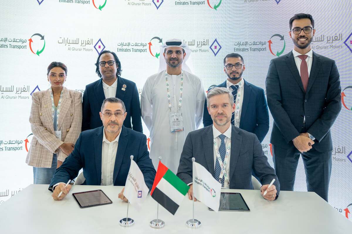 Business professionals signing documents at a UAE corporate event.