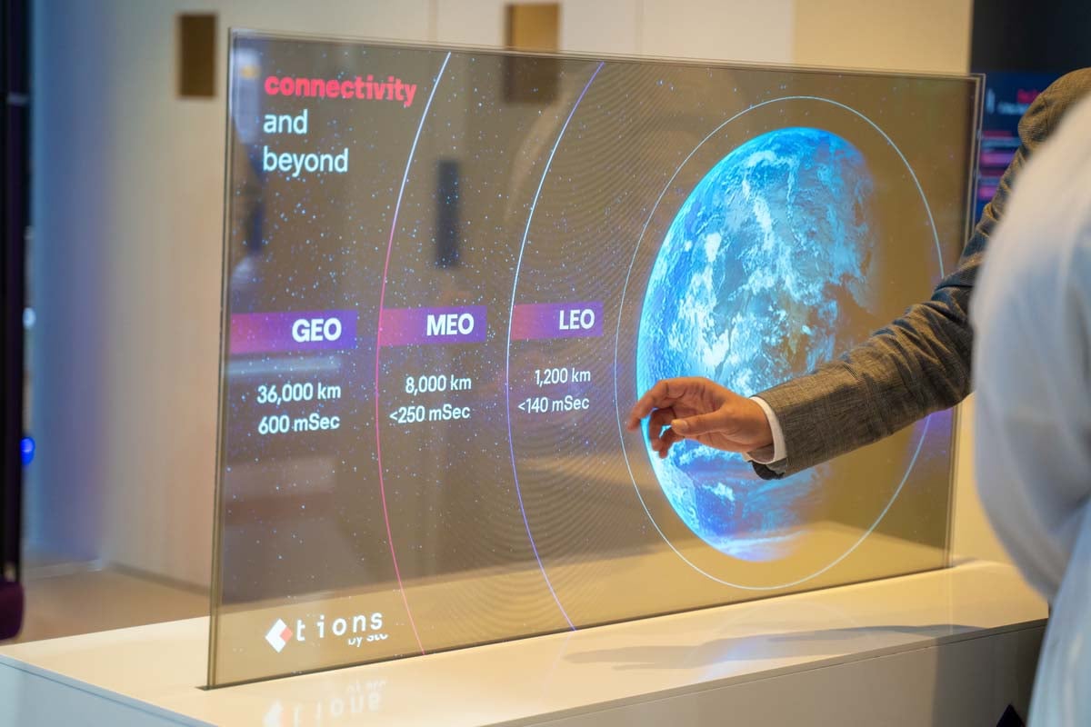 Person using transparent screen with Earth data.