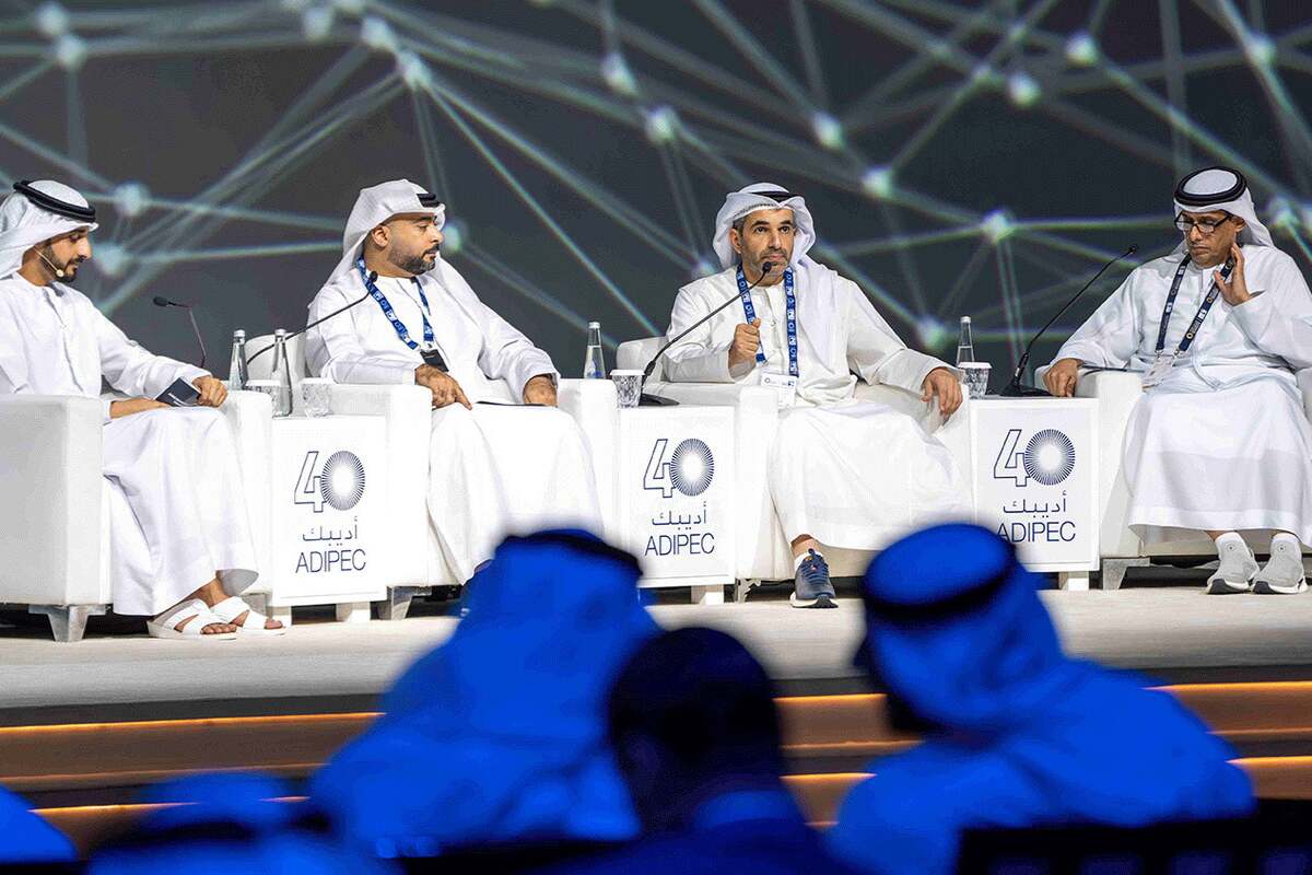 Four men in thobes on a panel at "40 ADIPEC" conference.