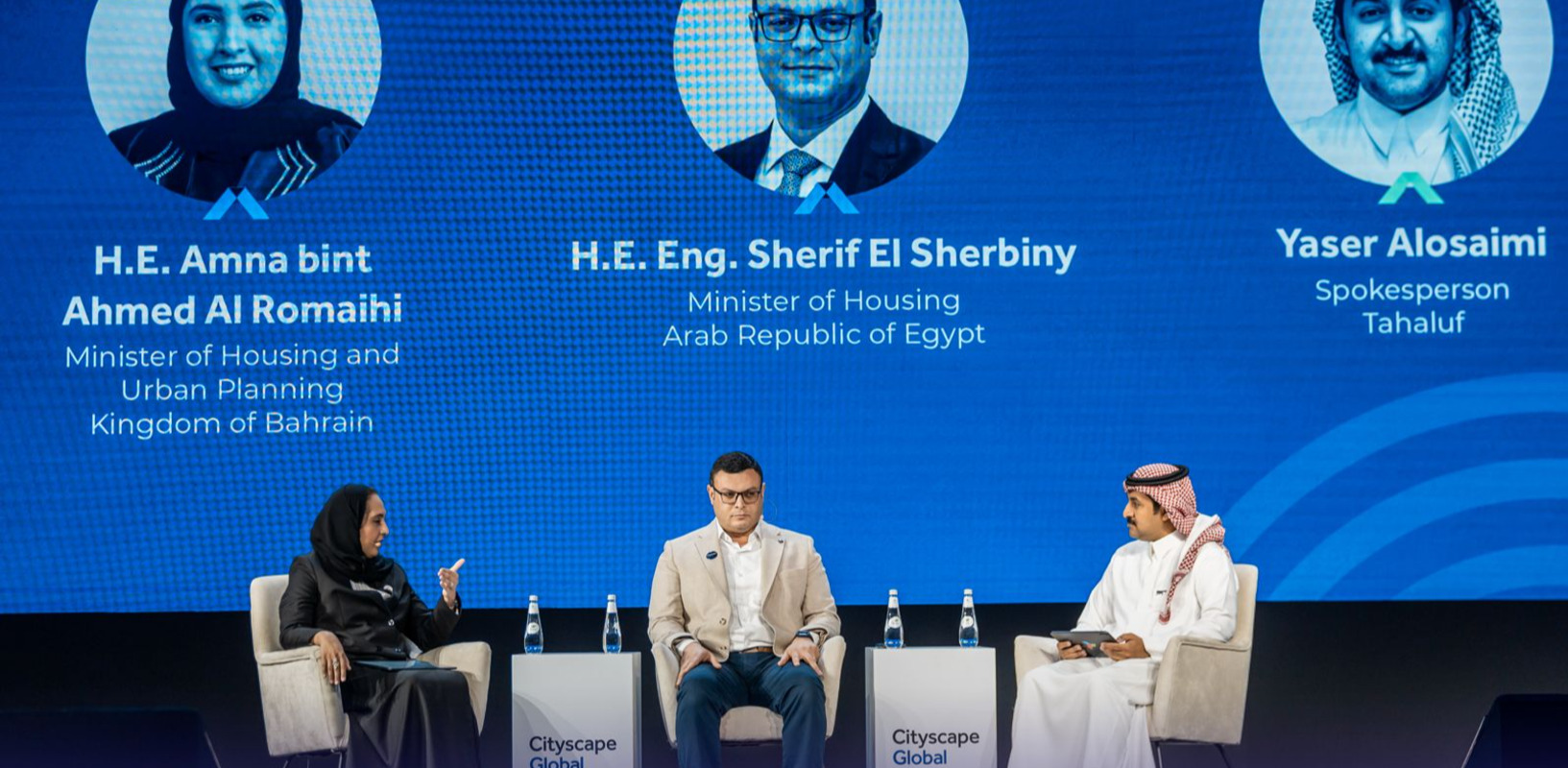 Panel discussion with blue backdrop.