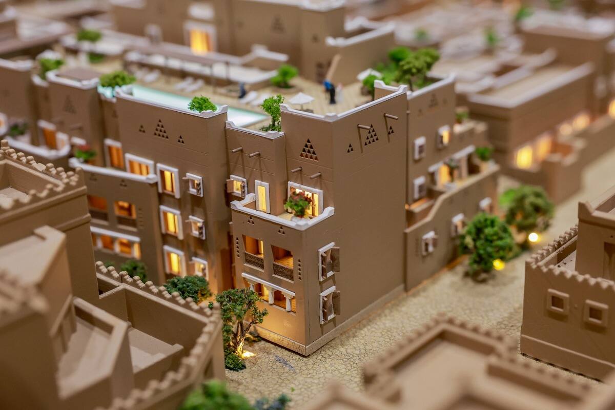 Detailed architectural model of multi-story building with trees and pool.